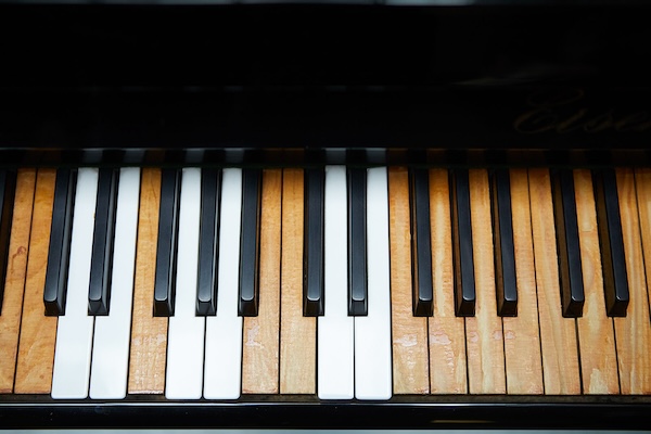 old piano keys, some discoloured where ivories have worn